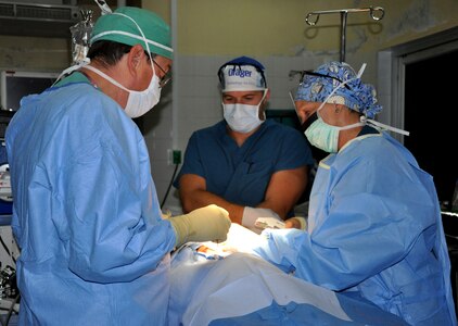 As part of a six-person mobile surgical team from Joint Task Force-Bravo U.S. Army Col. Ronald Rene, Medical Element general surgeon (left) and U.S. Army 1st Lt. Nicholas Kroll, MEDEL certified registered nurse anesthetist (center) watch as U.S. Army Capt. Lynda Moser, MEDEL operations room nurse (right), uses staples to close an incision after a successful gallbladder surgery Aug. 7, 2013 at a hospital in Comayagua, Honduras.  The surgical team assisted the hospital in removing three gallbladders and one bot fly larvae from a child’s body. MEDEL provides relevant, responsive care while enhancing the capabilities of partner nations.