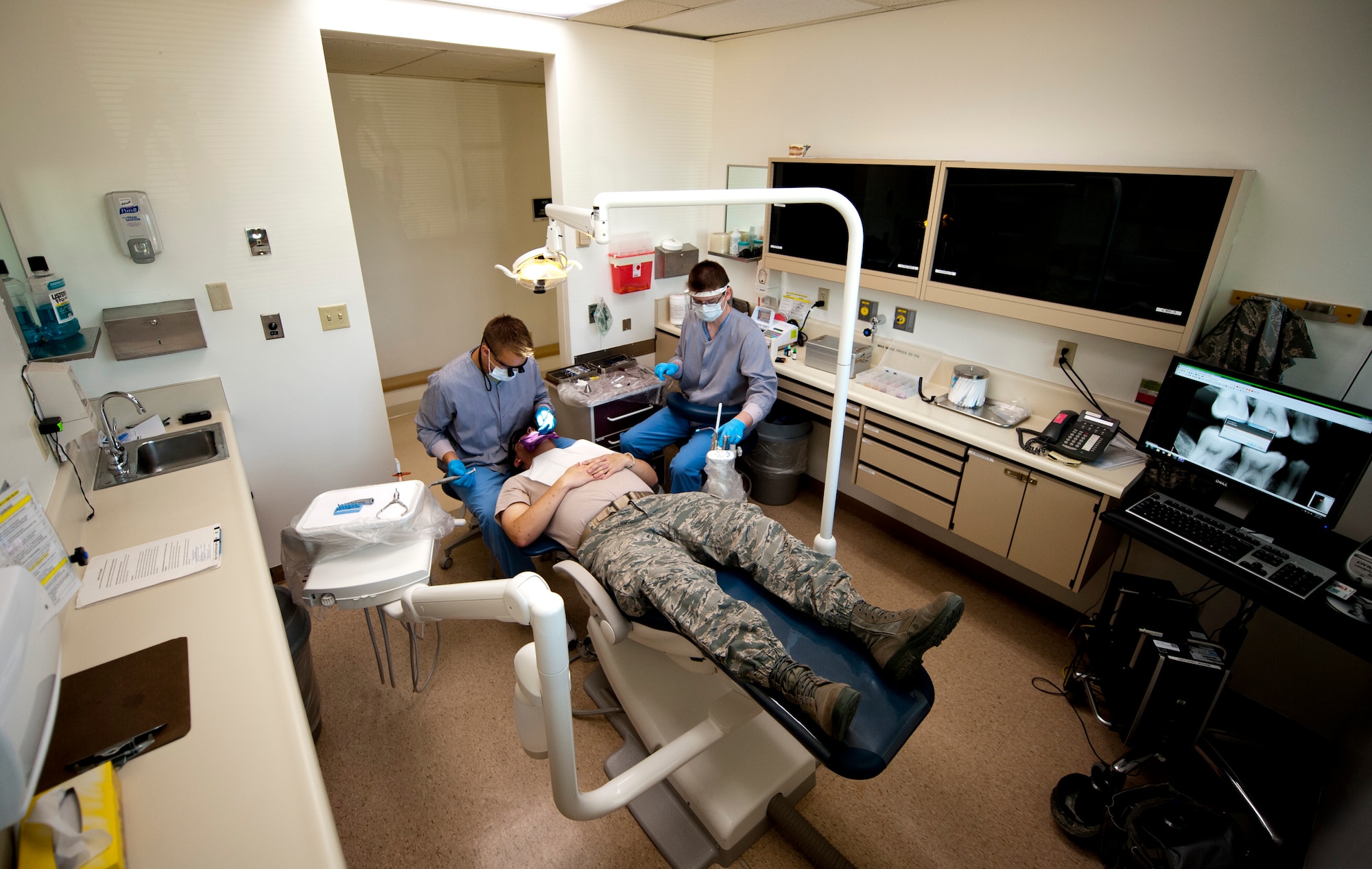 U.S. Air Force Capt. (Dr.) Nathan Fry, 366th Aerospace Medicine Squadron general dentist, and Airman 1st Class Yeugen Pylypchenko, 366th AMDS dental assistant, start to remove a cavity Aug. 5, 2013, at Mountain Home Air Force Base, Idaho. Fry was performing a tooth filling which involves removing the decayed portion of the tooth and then filling the hole with composite resin. (U.S. Air Force Photo by Airman 1st Class Brittany A. Chase/Released)