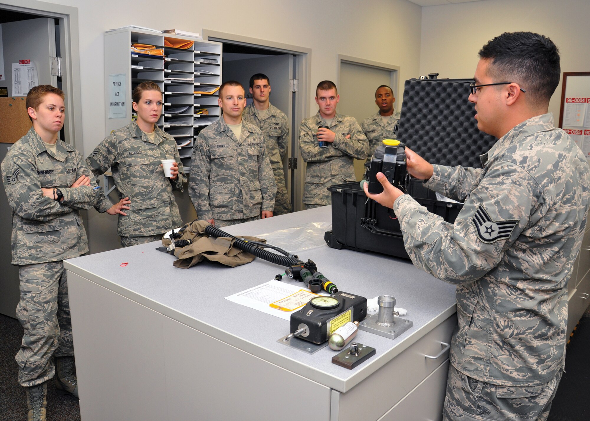 WRIGHT-PATTERSON AIR FORCE BASE, Ohio - Staff Sgt. Diego Cancino, 445th Operations Support Squadron aircrew flight equipment technician, explains the theories of operations pertaining to the aircrew chemical defense ensemble to participants of the July 13 89th Airlift Squadron hosted job swap.  Fourteen reservists from seven wing units participated in the job swap. (U.S. Air Force photo/Senior Airman Matthew Cook)