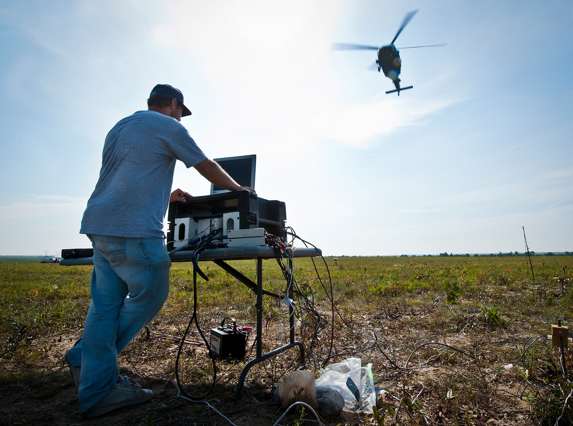 Joey Church, of System Engineering Integration Contract, monitors the sound data collection as an Army UH-60 Blackhawk flies overhead during Acoustic Week Aug. 6 at Eglin Air Force Base, Fla. The event is a three-week project hosted by the 46th Test Squadron and Project Chicken Little.  It is a cost-shared opportunity between the government and customers to collect specific and general sound data from ground and aerial vehicles.  The event began July 29 and ends Aug. 15.  (U.S. Air Force photo/Samuel King Jr.)
