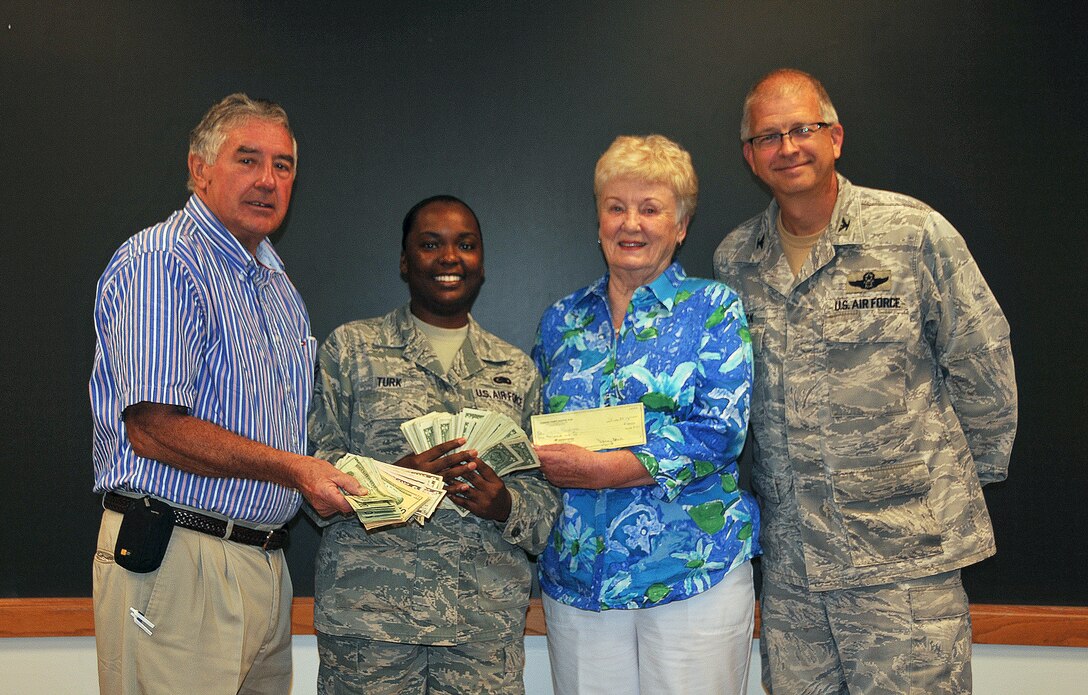 Col. Tim Tarchick, 94th Airlift Wing commander, and Staff Sgt. Jasmine Turk of the Airman and Family Readiness office accepted over $1,900 on Aug. 8 of funds raised during the Ninth Annual Corn & Sausage Roast, held last month, and the Dobbins Air Reserve Base Thrift Store. (U.S. Air Force photo/Senior Airman Elizabeth Van Patten)