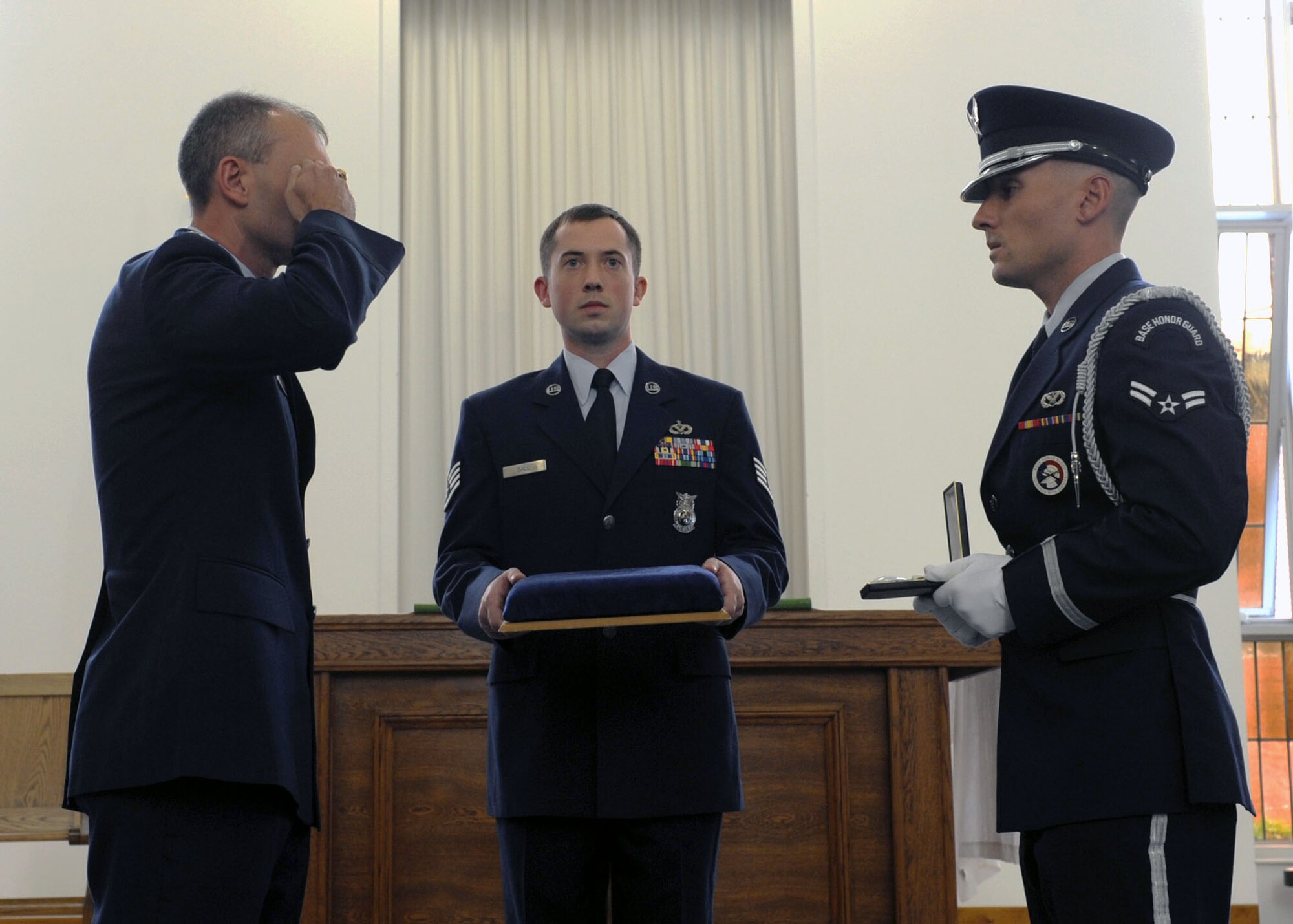 From left, U.S. Air Force Lt. Col. Kevin Parker, 100th Civil Engineer Squadron commander, presents the Air Force Commendation Medal posthumously to U.S. Air Force Airman 1st Class Stephen Beasley, 100th CES Heavy Equipment journeyman, who served as a proxy for U.S. Air Force Staff Sgt. Anderson Johnson during Johnson’s memorial service Aug. 12, 2013, at the base chapel on RAF Mildenhall, England. Johnson was an electrician in the 100th CES and is survived by his wife, Markeah Johnson. (U.S. Air Force photo by Airman 1st Class Preston Webb/Released)