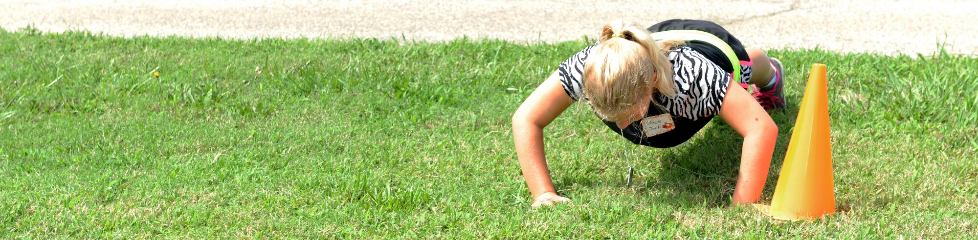 Kaylee Jenkins completes push-ups as part of the obstacle course during Operation Hero at Langley Air Force Base, Va., Aug. 7, 2013. The obstacle course emphasized the importance of physical training in the Air Force. (U.S. Air Force photo by Airman 1st Class Kimberly Nagle/Released)