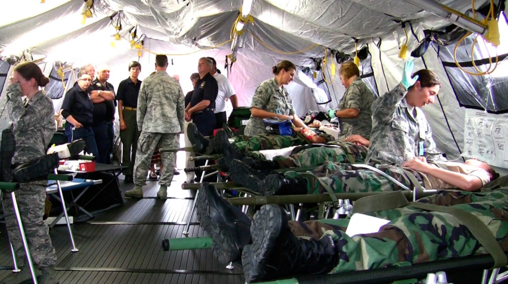 Airmen from the 139th Aeromedical Evacuation Squadron of the 109th Airlift Wing, while working with civilian agencies, provide treatment during an exercise to simulated patients, Civil Air Patrol cadets, after they were brought to the base from the Aplaus Fire Department, Aug. 8, 2013. (U.S. Air National Guard photo by Master Sgt. William M. Gizara/Released)
