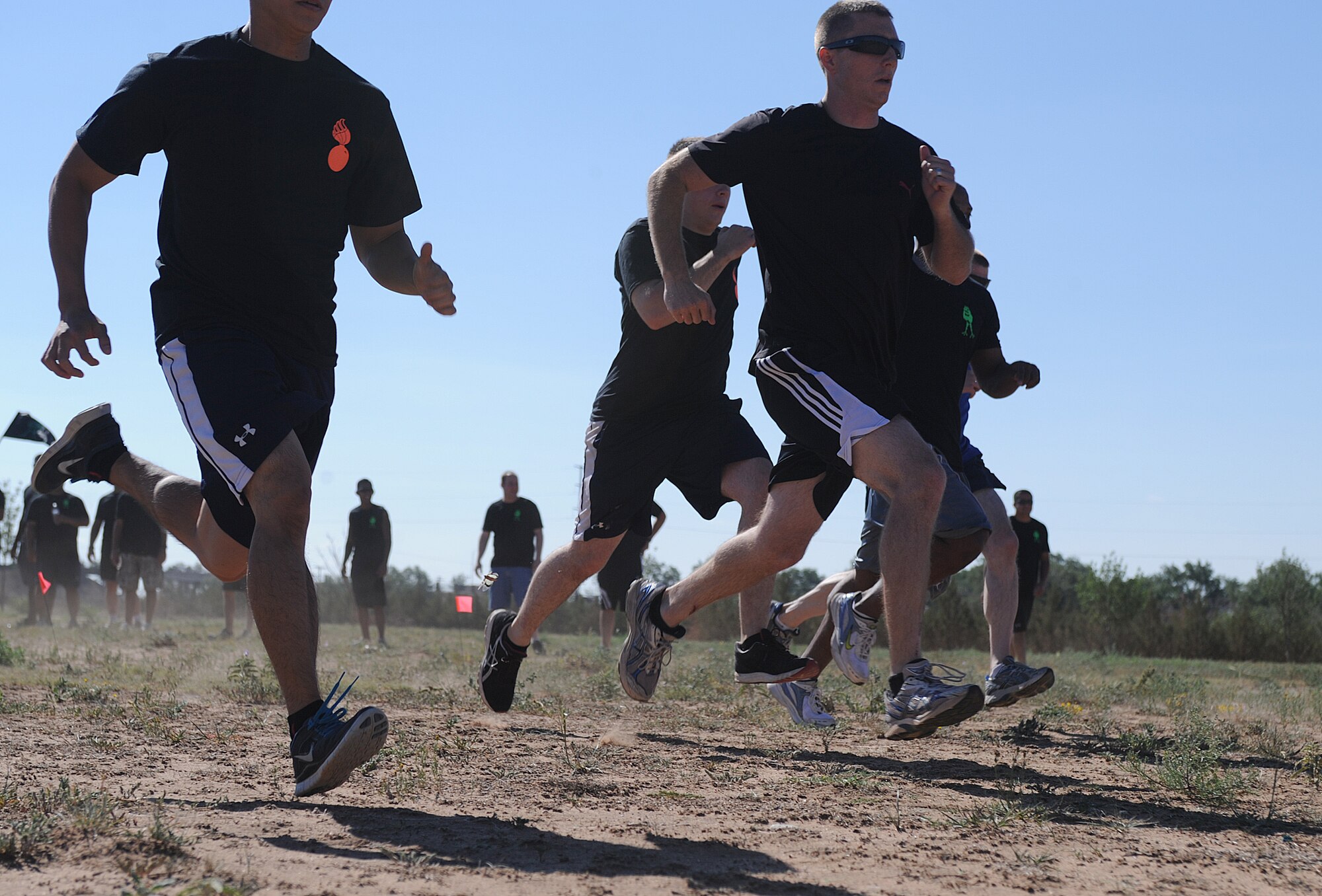 Competitors in a relay race sprint toward the finish line during the Weapons and Ammo competition Aug. 9, 2013 at Cannon Air Force Base, N.M. The competition was a daylong event with games and activities for military members and their families. (U.S. Air Force photo/Senior Airman Ericka Engblom)