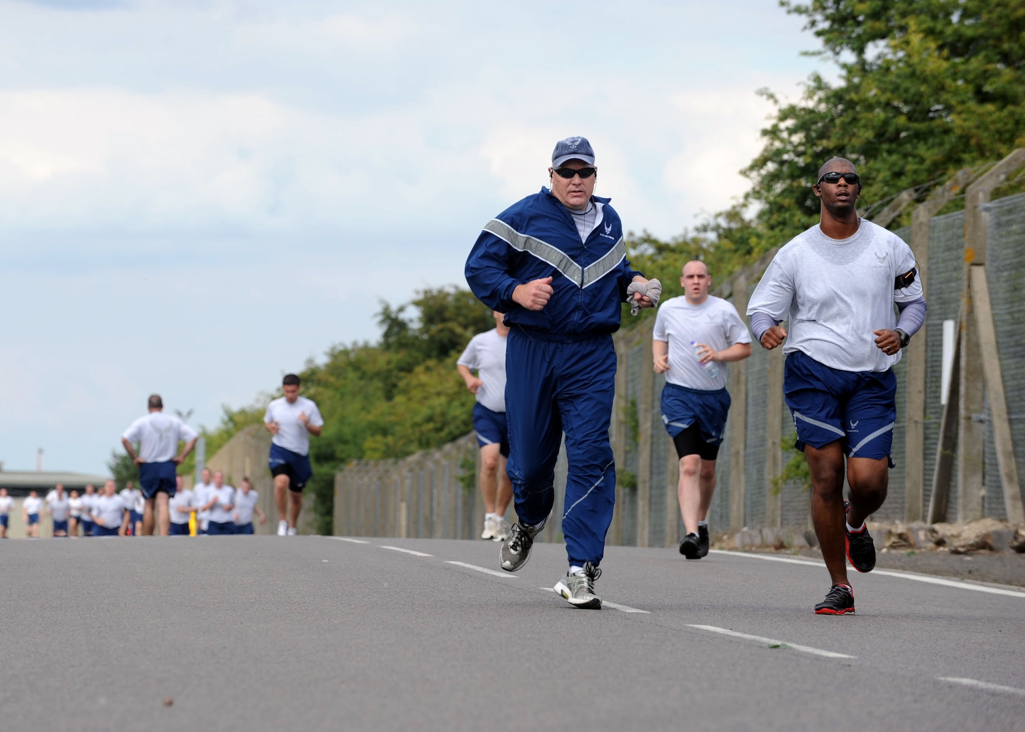 Team Mildenhall members jog the final leg of the 100th Air Refueling Wing 5 km run Aug. 9, 2013, on RAF Mildenhall, England. Each month, members of the 100th ARW gather near the Hardstand Fitness Center for exercise and friendly competition. (U.S. Air Force photo by Airman 1st Class Preston Webb/Released)