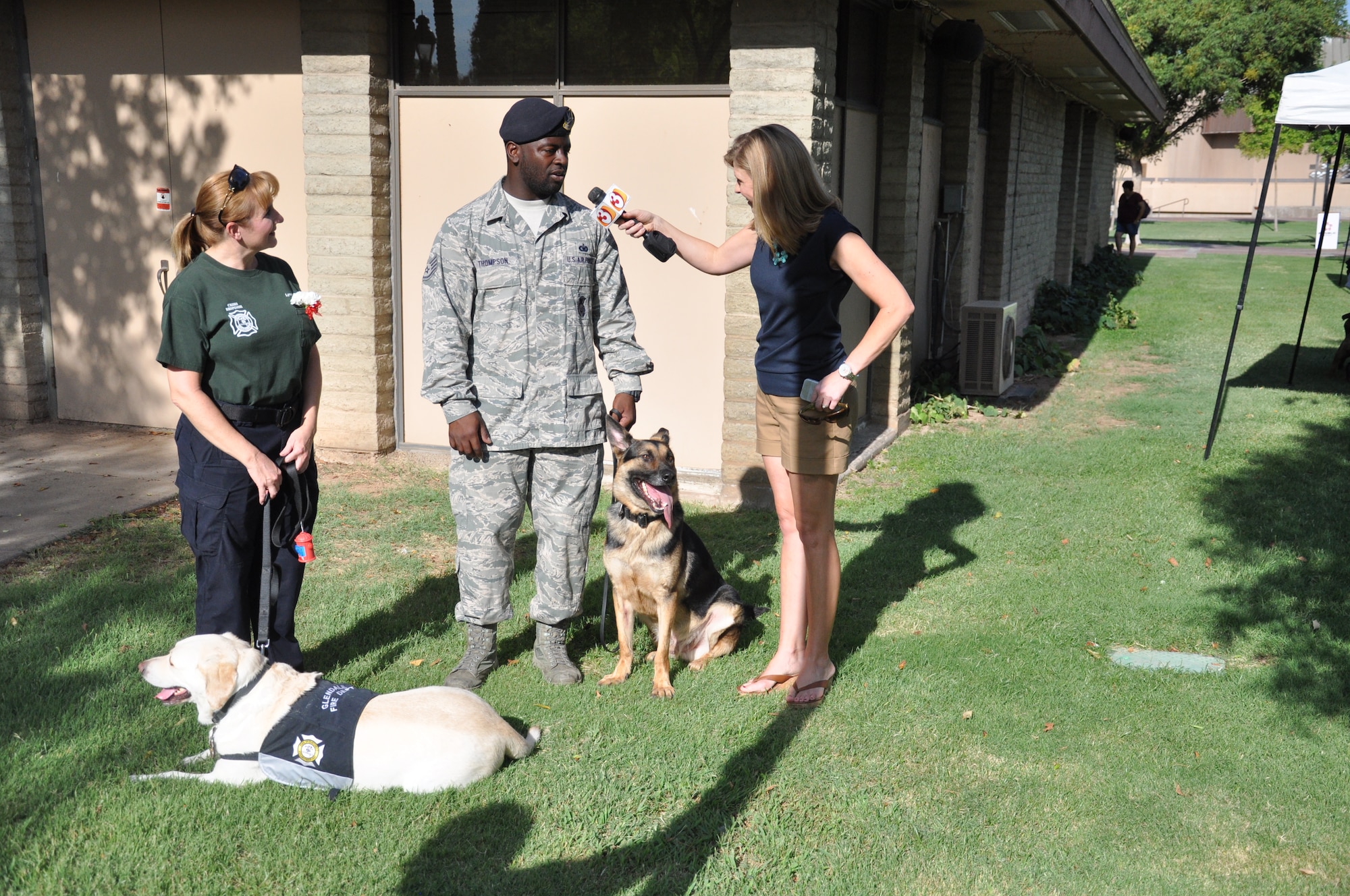 Staff Sgt. Lindsey Thompson, 56th Security Forces Squadron Military Working Dog handler, and Wax, 56th SFS military working dog, are interviewed by local media about their participation in the annual Dogs Days of Summer event. Thompson and Wax have worked together as a team for more than a year. (U.S. Air Force photo/Staff Sgt. Luther Mitchell)