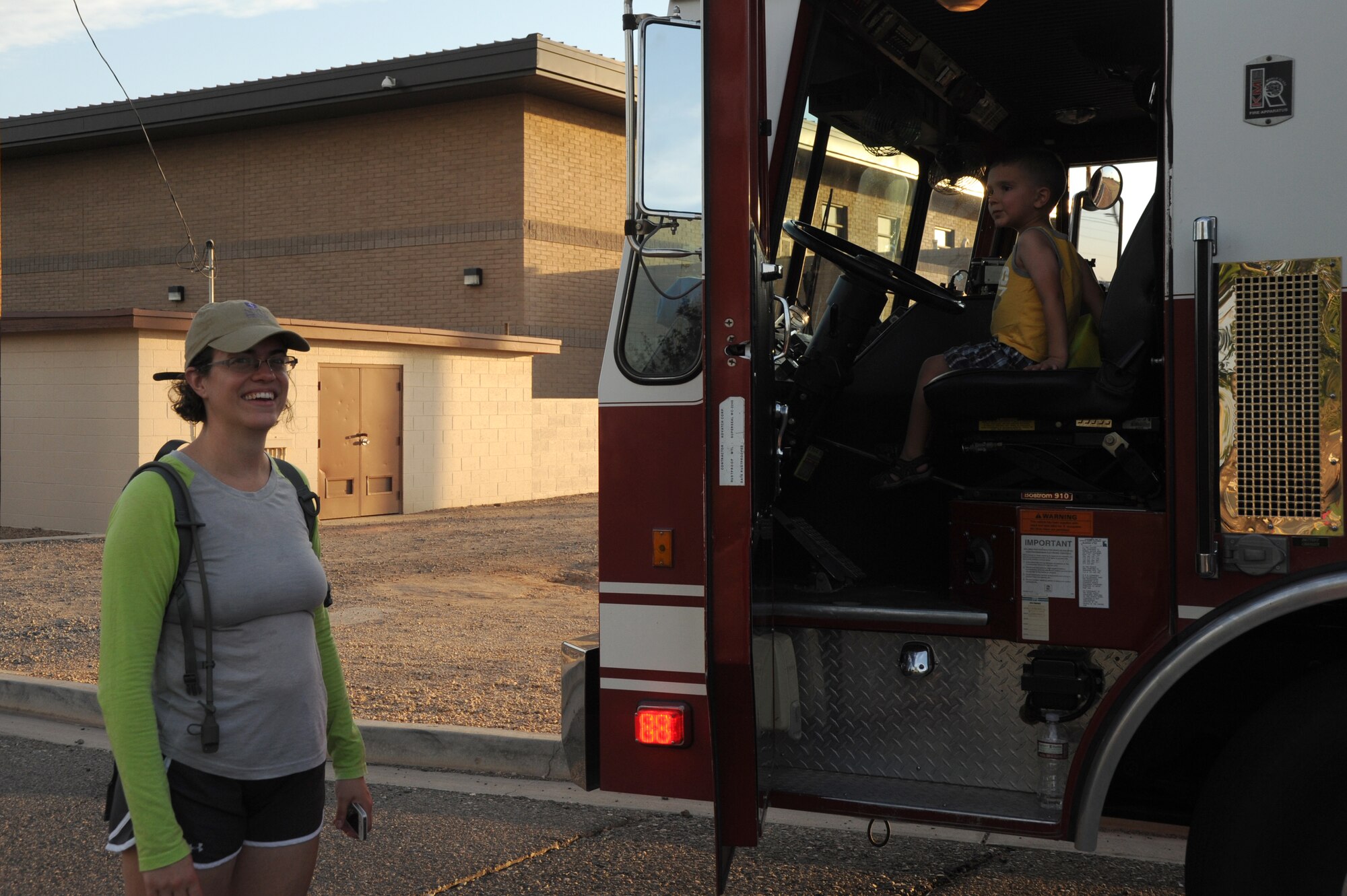 Maj. Cristina Franchetti, 56th Medical Operations Squadron general surgery officer-in-charge, watches as her son climbs through a fire engine, an interactive display provided by the 56th Civil Engineer Squadron Fire Emergency Services. (U.S. Air Force photo/Airman 1st Class Pedro Mota)