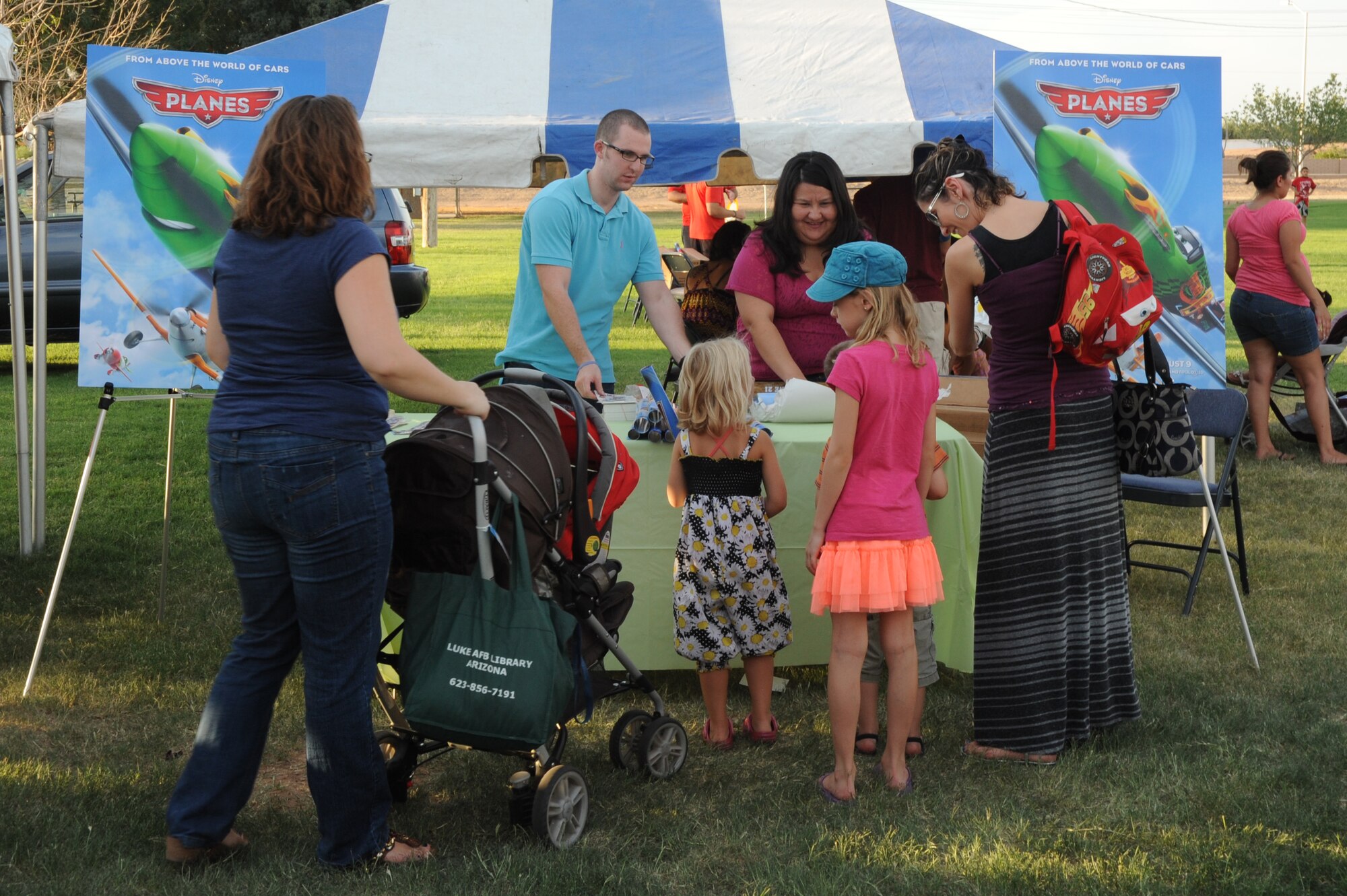 Luke family members visit a Disney display featuring the upcoming movie “Planes” at this year’s Back to School Bash Aug. 2 held at Fowler Park on Luke Air Force Base. Tickets to the premiere of the movie, as well as school supplies, were passed out. (U.S. Air Force photo/Airman 1st Class Pedro Mota)