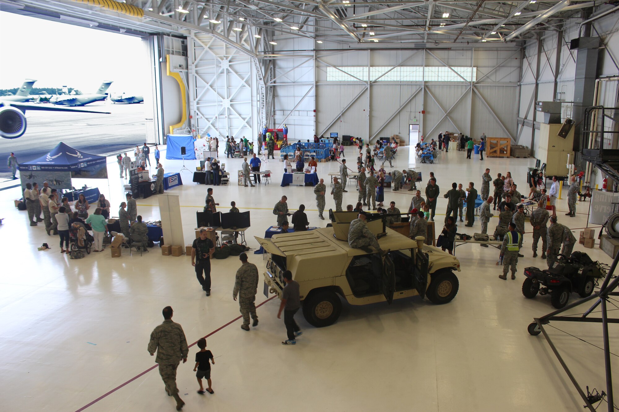 Members of the 446th Airlift Wing, along with their family members, learn about various Air Force job specialties at Hangar 9 on McChord Field,, Wash., as part of the wing's Reserve Family Symposium Aug. 10. The event featured information on Airman and Family Readiness, the Care and Share program, the Wingman Toolkit, Air Force Reserve Yellow Ribbon Program, Hero 2 Hired, Employer Support of the Guard and Reserve, Air Force Aid Society, veteran benefits, TRICARE (medical and dental), fitness opportunities and military family and life counselors. (U.S. Air Force Reserve Photo/Staff Sgt. Rachael Garneau)