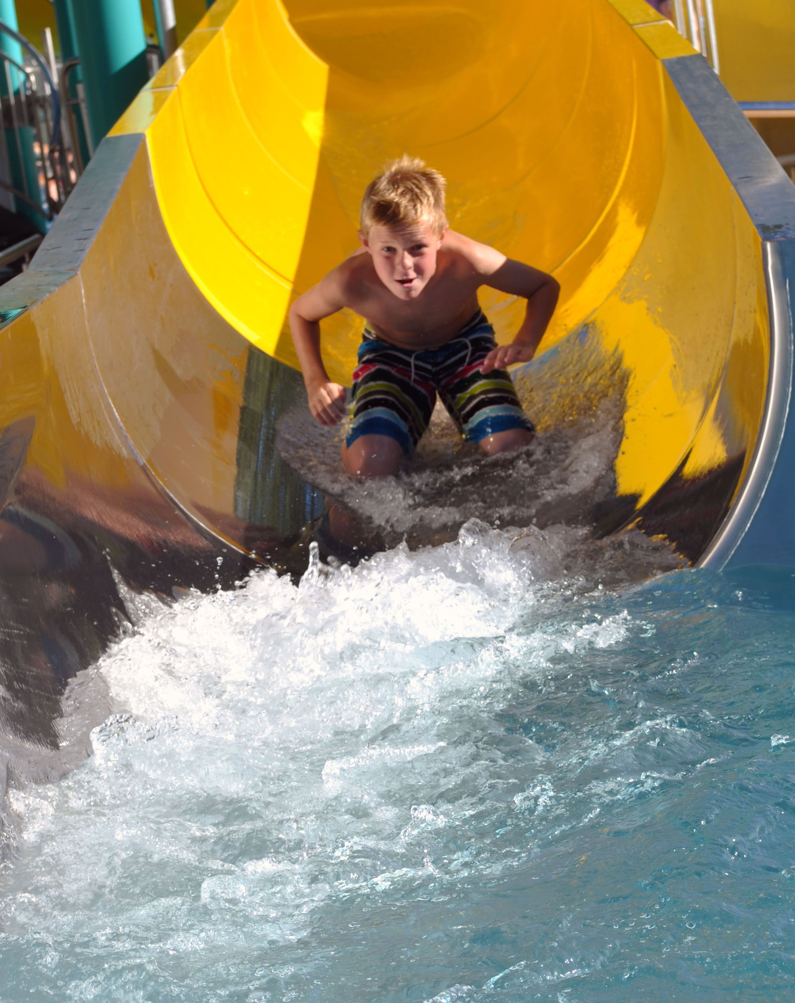 A child rides a six meter long water slide at the Schweich swimming and entertainment pool complex.  The Eifel region has more than 20 public pools, numerous lakes and outdoor swimming pools. Most public pools are open now for the summer and will close again at the end of September.  Opening times and entry prices vary for each pool, but most of them typically run between 2-4 Euro for adults and 1.50-2.50 Euro for children. (U.S. Air Force photo by Iris Reiff/Released) 