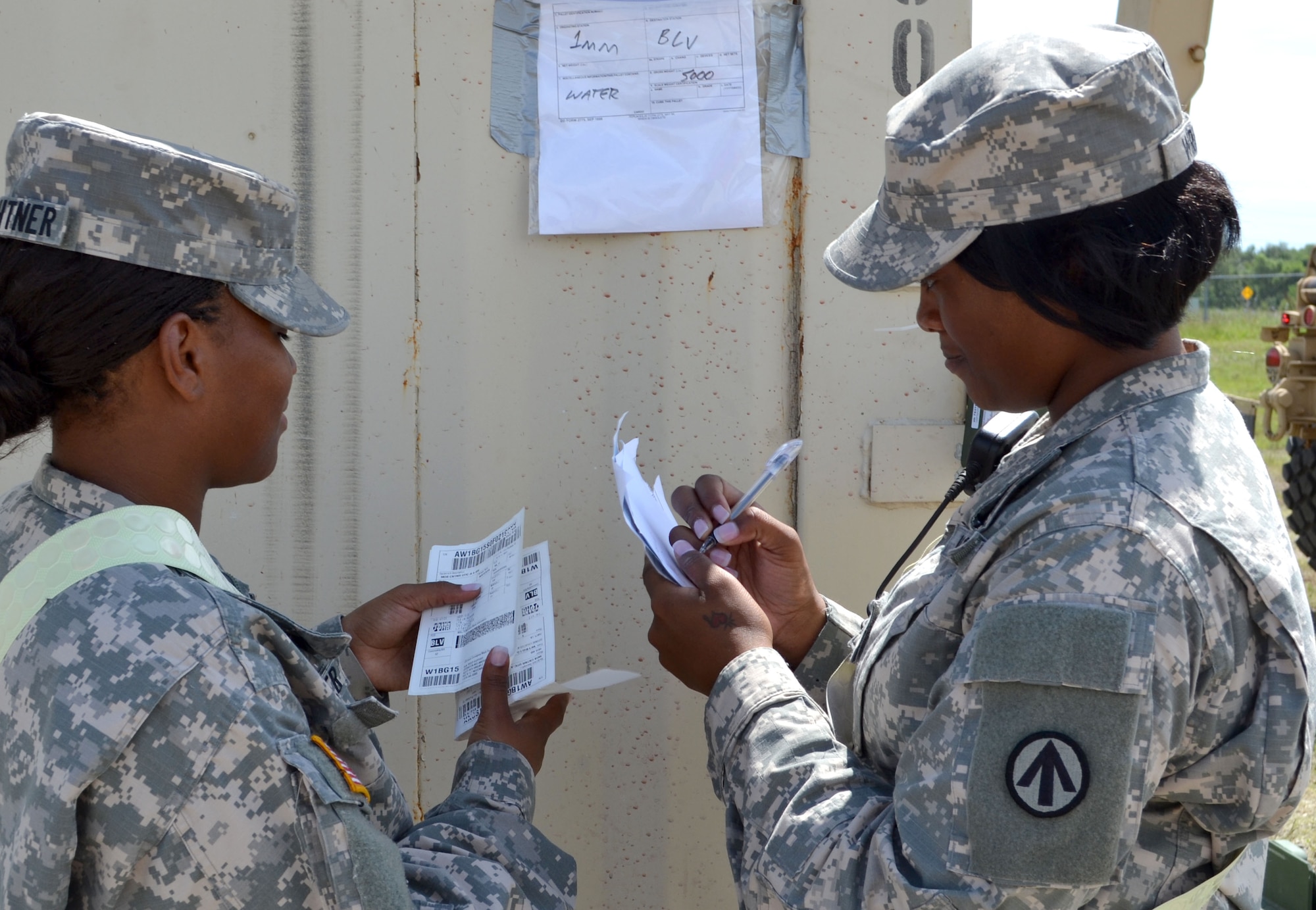 Spc. Marsha Feightner and Spc. Antoinette Wright, transportation document specialists for the 689th Rapid Port Opening Element from Joint Base Langley-Eustis, Va., double-check container paperwork ensuring the right equipment is in the right place at the forward distribution node supporting Operation Gateway Relief. (Courtesy photo/Released)