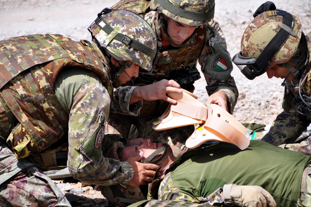 Italian soldiers treat a simulated casualty as part of a demonstration on Forward Operating Base Farah, Afghanistan, Aug. 8, 2013. The Italian soldiers are assigned to Transition Support Unit South.