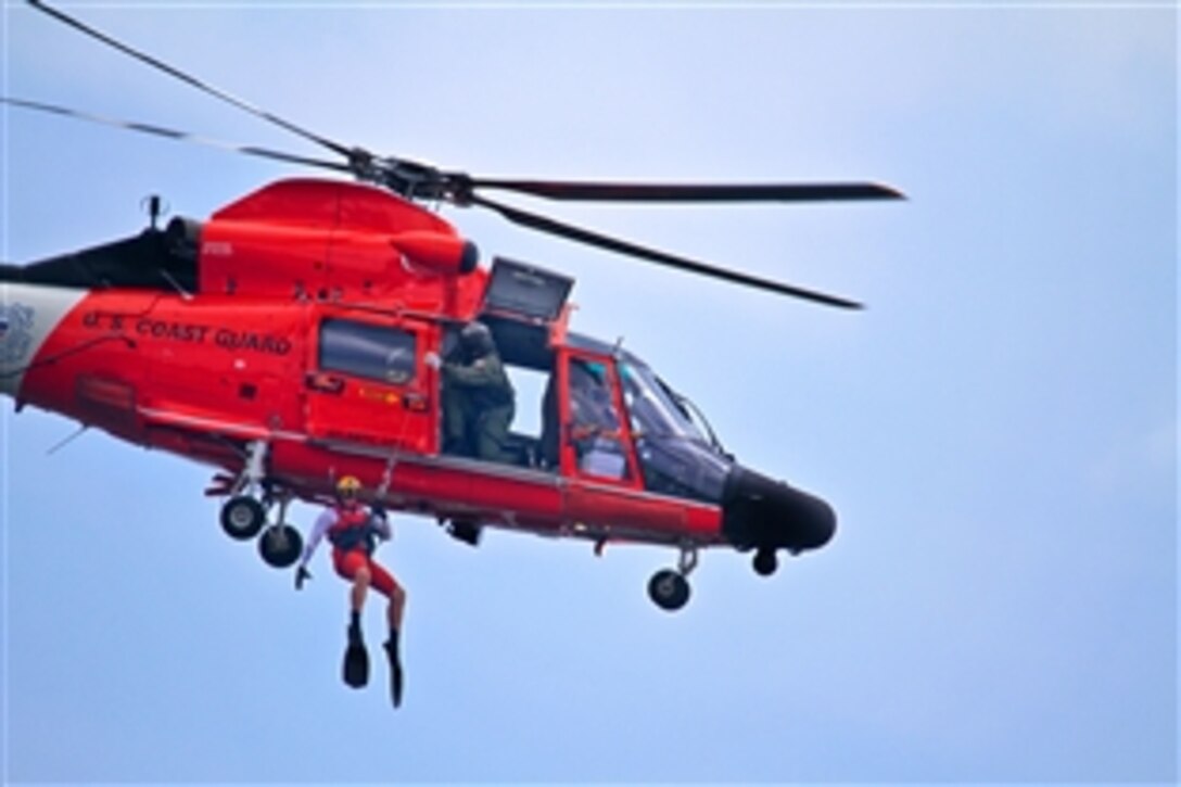 A U.S. Coast Guardsman is lowered from a HH-65C Dolphin helicopter to assist an airman out of the water during a joint training exercise in Port Republic, N.J., Aug. 9, 2013. The airman is assigned to the New Jersey Air National Guard's 177th Fighter Wing, and the aircrew is assigned to the U.S. Coast Guard Air Station Atlantic City. The 177th Fighter Wing and U.S. Coast Guard Air Station Atlantic City are both based out of the Atlantic City International Airport, N.J.