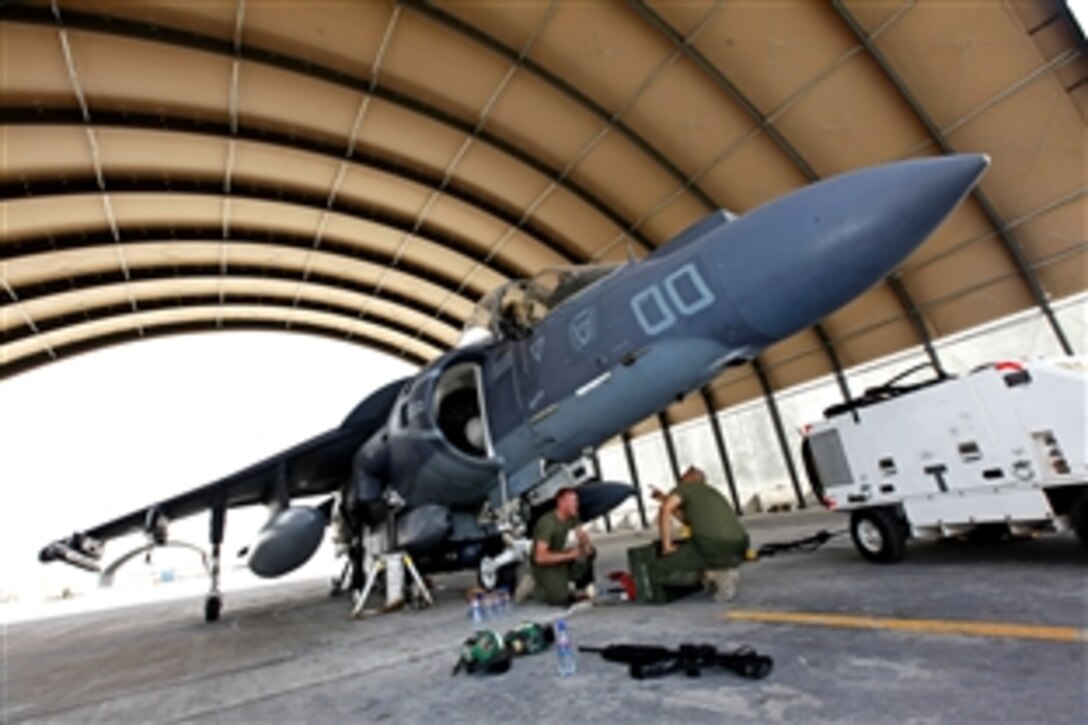 U.S. Marines Corps Lance Cpl. Jason D. Launder, left, and U.S. Marine Corps Cpl. Noe L. Munoz troubleshoot and replace the landing gear system on an AV-8B Harrier aircraft on Camp Bastion in Helmand province, Afghanistan, Aug. 9, 2013. Launder, an avionics technician, and Munoz, a collateral duty inspector, are both with Marine Attack Squadron 311. Maintenance was conducted to ensure the aircraft met the operational standards for flight.