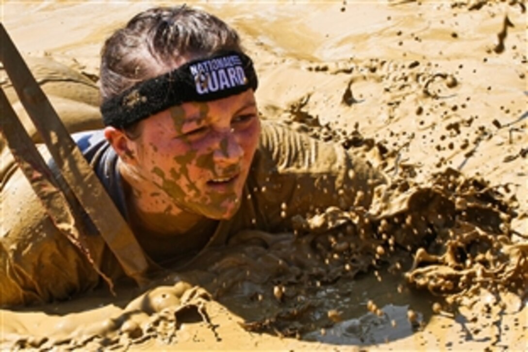 Army 2nd Lt. Mary Kauffman crawls through mud during the Warrior Dash 5k mud run in North Lawrence, Ohio, Aug. 11, 2013. Kauffman and 19 other Ohio National Guardsman participated in the event to promote recruiting and retention. Kauffam, a member of the Ohio National Guard, is assigned to the 112th Motor Transport Battalion.