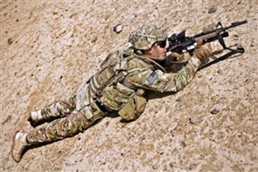 U.S. Army Staff Sgt. Matthew Morin scans the area and a culvert for improvised explosive devices in Kandahar province, Afghanistan, Aug. 7, 2013. Morin is assigned to Engineer Troop, Regimental Support Squadron, Combined Task Force Dragoon.