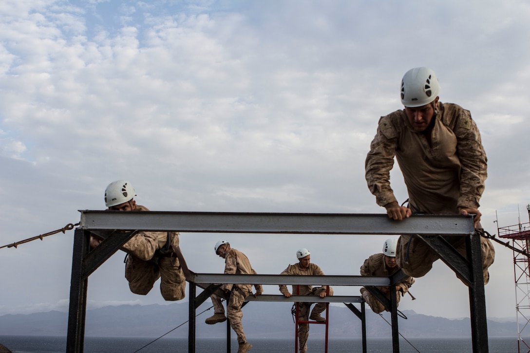 U.S. Marines of Company K, Battalion Landing Team 3/2, 26th Marine Expeditionary Unit (MEU), climb over a vertical obstacle in a squad obstacle course as part of their sustainment training in Djibouti, Aug. 5, 2013. The 26th MEU is a Marine Air-Ground Task Force forward-deployed to the U.S. 5th Fleet area of responsibility aboard the Kearsarge Amphibious Ready Group serving as a sea-based, expeditionary crisis response force capable of conducting amphibious operations across the full range of military operations. (U.S. Marine Corps photo by Cpl. Michael S. Lockett/Released)
