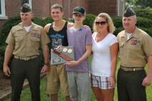 Lt. Col. William Stophel, the commanding officer for Combat Logistics Battalion 2, 2nd Marine Logistics Group, UFC Fighter Stephen Thompson, Austin Saxton, Christina Saxton, and Capt. Lee Stuckey, the company commander for Transportation and Support Company, Combat Logistics Battalion 2, 2nd Marine Logistics Group, pose for a photo after Austin was awarded a plaque for being a true warrior at Camp Lejeune, N.C., Aug. 02, 2013. Austin was diagnosed with Pancreatic and liver cancer, but never gave up fighting.  (U.S. Marine Corps photo by Cpl. Devin Nichols)