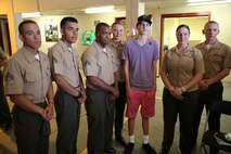 Austin Saxton poses for a photo with Marines with Transportation and Support Company, Combat Logistics Battalion 2, 2nd Marine Logistics Group aboard Camp Lejeune, N.C., Aug. 02, 2013. The Marines were so touched by his story, that some of them awarded him the ribbons they earned in combat. (U.S. Marine Corps photo by Cpl. Devin Nichols)