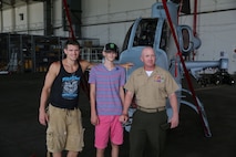 Ultimate Fighting Championship fighter Stephen “Wonderboy” Thompson, Austin Saxton, and Capt. Lee Stuckey, the company commander for Transportation and Support Company, Combat Logistics Battalion 2, 2nd Marine Logistics Group, pose for a photo in front of a Cobra Helicopter aboard Marine Corps Air Station New River, Aug. 02, 2013. Austin has always dreamt of being a Marine like his dad, and meeting a real UFC fighter. (U.S. Marine Corps photo by Cpl. Devin Nichols)