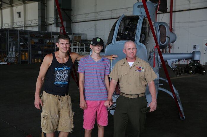 Ultimate Fighting Championship fighter Stephen “Wonderboy” Thompson, Austin Saxton, and Capt. Lee Stuckey, the company commander for Transportation and Support Company, Combat Logistics Battalion 2, 2nd Marine Logistics Group, pose for a photo in front of a Cobra Helicopter aboard Marine Corps Air Station New River, Aug. 02, 2013. Austin has always dreamt of being a Marine like his dad, and meeting a real UFC fighter. (U.S. Marine Corps photo by Cpl. Devin Nichols)