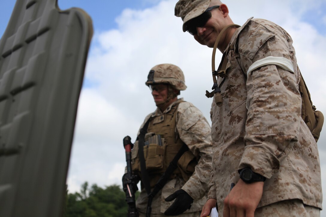 Range coach, Lance Cpl. Jacob Engel of 3rd Platoon, Company G, 2nd Battalion, 24th Marine Regiment, and shooter, Sgt. Michael Weiland of Headquarters Platoon, Co. G, 2/24 examine Weiland’s target after a round of rifle qualifications at Camp Atterbury, Ind., Aug. 9. Both Co. G from Madison, Wis. and Co. F from Milwaukee, Wis. travelled to Camp Atterbury as part of their required rifle qualifications. (U.S. Marine Corps photo by Lance Cpl. Tiffany Edwards)