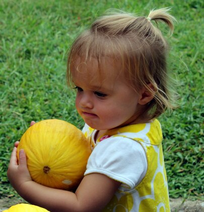 Emilia, 18 months, clutches a melon at the grand opening of Quantico’s farmers market Aug. 8, 2013, on the Marine Corps Exchange parking lot aboard Marine Corps Base Quantico.