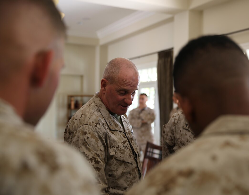 Maj. Gen. Steven W.  Busby, commanding general 3rd Marine Aircraft Wing, regales a few Marines with tales of how he acquired an entire challenge coin collection during a luncheon in his home aboard Marine Corps Air Station Miramar, Calif. Aug 12. Busby invited Marines and spouses of Marine Wing Support Squadron 373 to lunch in honor of their participation in the Veterans Village of San Diego Stand Down.
