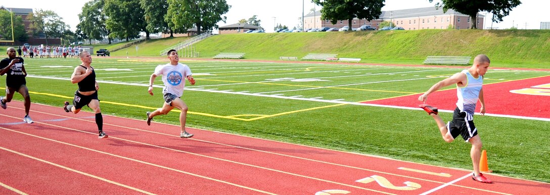 Lance Cpl. Chris Tipton, Marine Corps Air Facility, leans into the final stride to cross the finish line in first place after a 200-meter dash during a Track and Field meet Aug. 8, 2013, at Butler Stadium aboard Marine Corps Base Quantico. The shotput throw and relay races were among the events hosted.