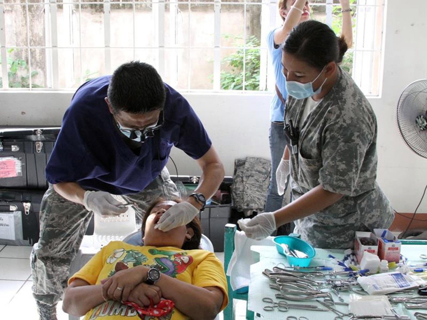 Members of a joint medical team treat a young dental patient in the Phillipines. Medical personnel treated nearly 13,000 people.