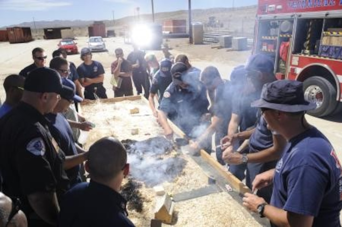 Firefighters of the Marine Corps Logistics Base Barstow, Calif., fire department take part in simulation training, July 31. The training allowed multiple teams to coordinate their efforts on a model terrain with a real fire.


