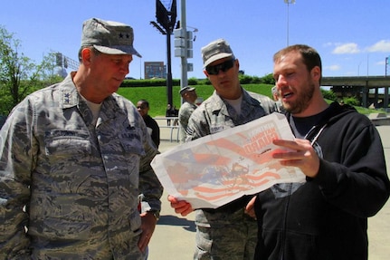 Kentucky's adjutant general, Maj. Gen. Edward W. Tonini, and State Command Chief Master Sgt. James Smith discuss the plans of a new National Guard mural with artist Nick Accuroso at the Louisville Extreme Park, April 20, 2013.