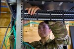 U.S. Air Force Senior Airman Tarah White, 160th Theater Signal Support Brigade airfield systems journeyman, punches down category five cable to a patch panel, March 19, 2013, at Bagram Airfield, Afghanistan.