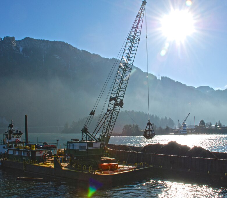 Corps contractors dredge sediment near Bonneville Dam. If not removed by dredging, sediment can enter a flow channel where it can settle inside the dam structure, where its removal is much more difficult.