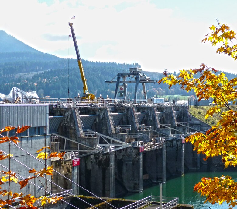 In the Willamette Valley, Dexter Dam’s permanent gantry crane stands sentry as a mobile crane supports spillway gate repairs. The mobile crane lifts a new gate arm into place.