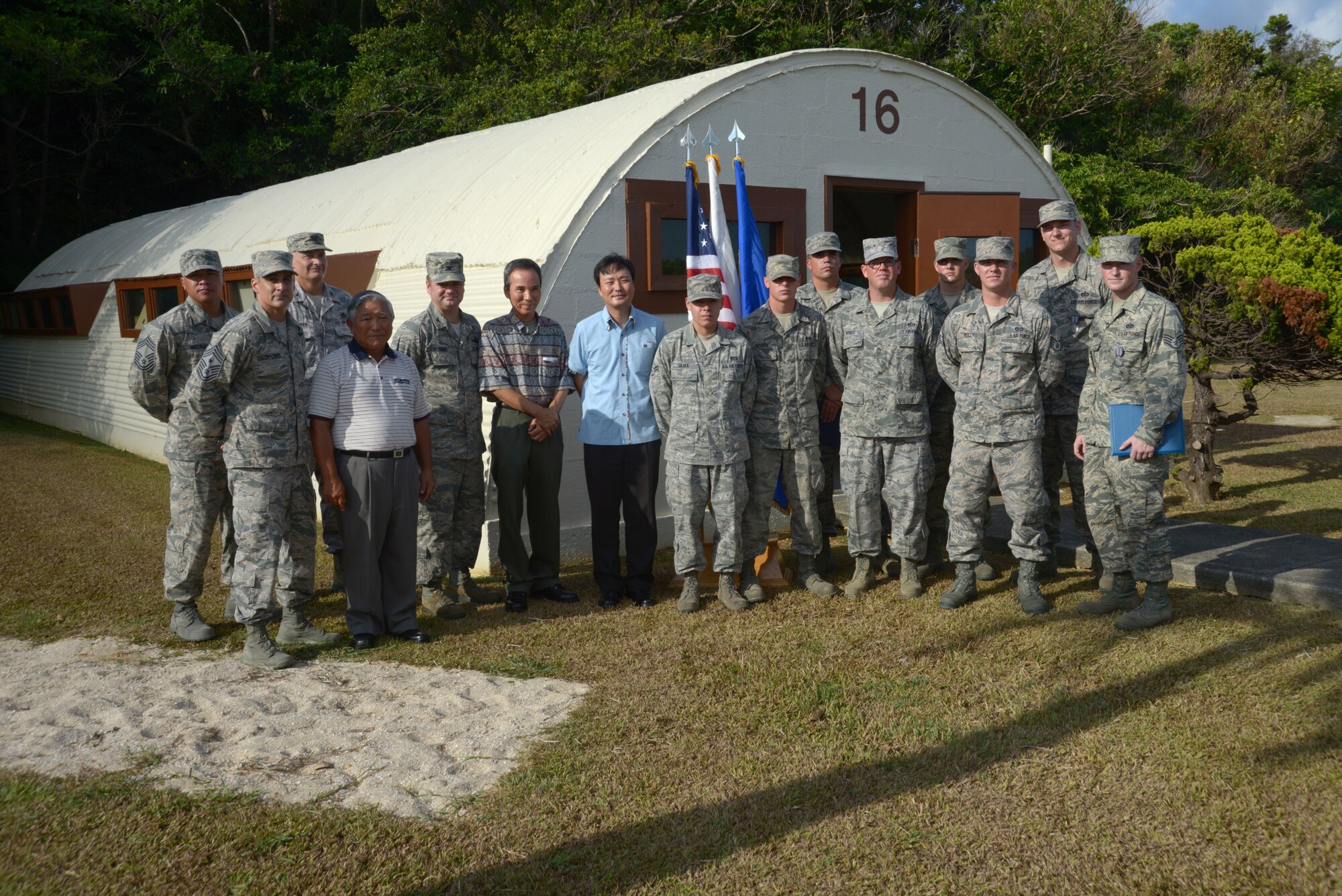 Members of the 18th Civil Engineer Squadron who volunteered their time and skills to renovate the last standing Quonset hut on Kadena Air Base, Japan, stand in front of the newly unveiled piece of Kadena history, along with Col. Charles McDaniel, 18th Wing vice commander, Chief Master Sgt. Ramon Colon-Lopez, 18th Wing command chief, and distinguished guests Sadashi HIga, Kazuto Higa and Jimmy Schwartz, Aug. 12, 2013. (U.S. Air Force photo by Tech. Sgt. Jocelyn Rich-Pendracki/Released)