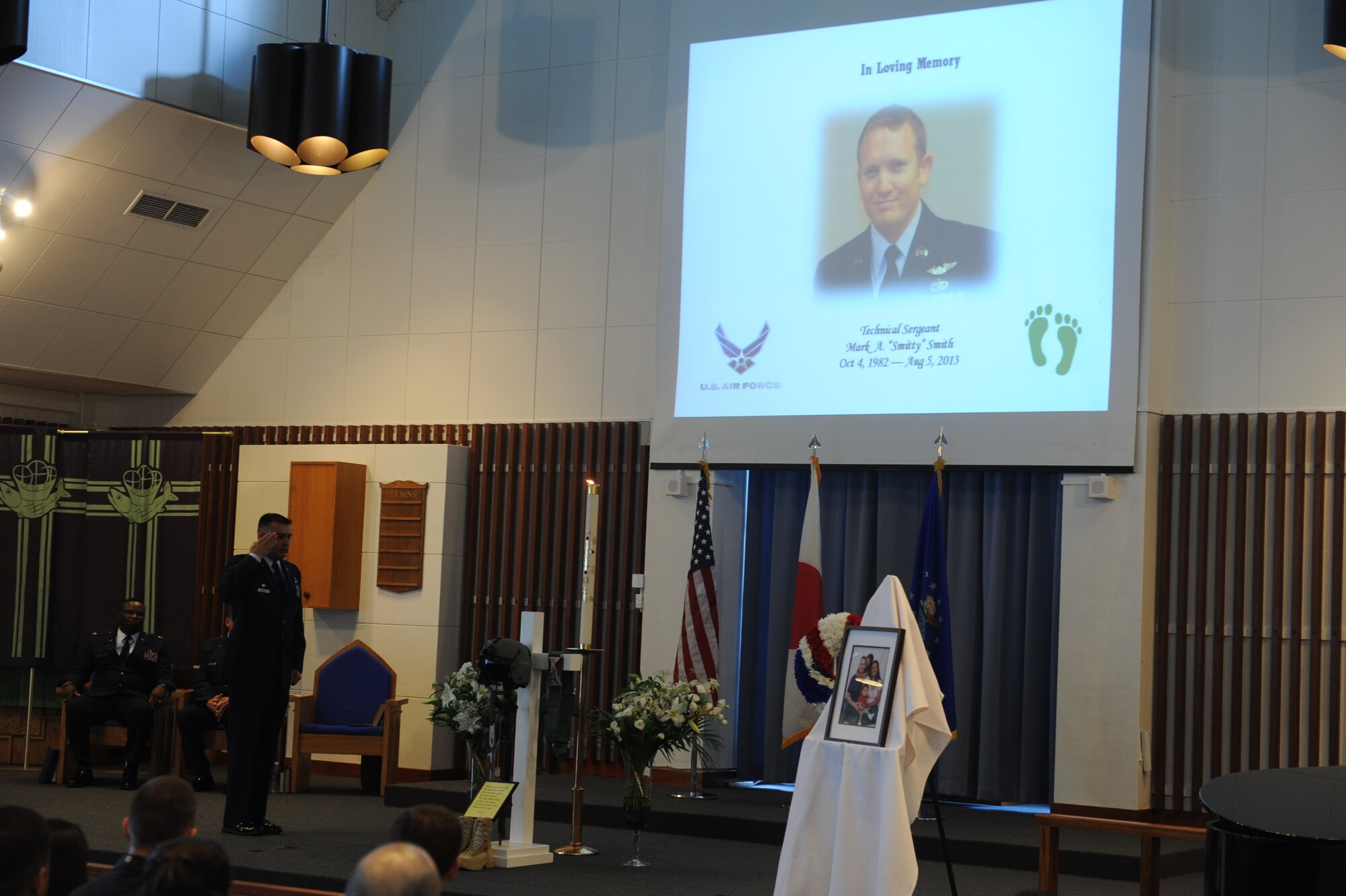 U.S. Air Force Lt. Col. Pedro Ortiz, 33rd Rescue Squadron commander, salutes the memorial dedicated to Tech. Sgt. Mark Smith during a memorial service at Chapel One on Kadena Air Base, Japan, Aug. 13, 2013. Service members from all over the base came to pay respect to Smith. (U.S. Air Force photo by Airman 1st Class Justin Veazie/Released) 