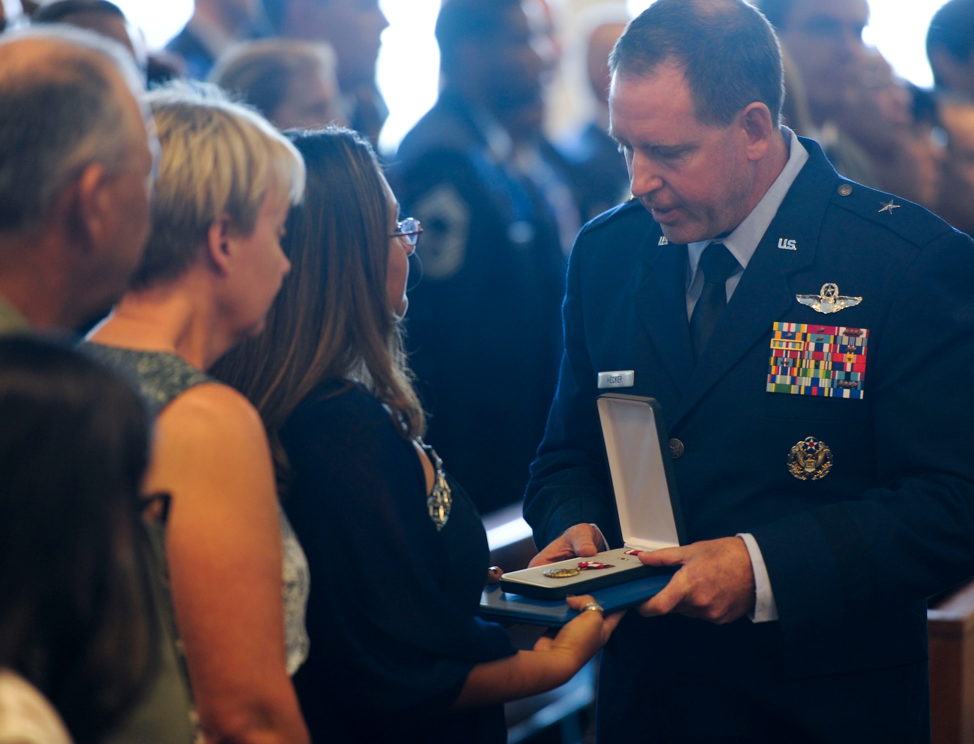 U.S. Air Force Brig. Gen. James Hecker, 18th Wing commander, presents a Meritorious Service Medal to Tech. Sgt. Mark Smith's spouse, Jessica, during a memorial service at Chapel One on Kadena Air Base, Japan, Aug. 13, 2013. The MSM was awarded to Smith posthumously. (U.S. Air Force photo by Airman 1st Class Justin Veazie/Released)