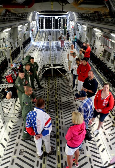 Reservists from the 446th Aeromedical Evacuation Squadron brief Boeing employees and their families about the mission of AES Aug. 11 in a static C-17 Globemaster III at Hangar 9. The civilians were given the opportunity to tour the aircraft, try out some of the gear, and test a few of the controls. (U.S. Air Force Reserve Photo/Airman 1st Class Madelyn McCullough)