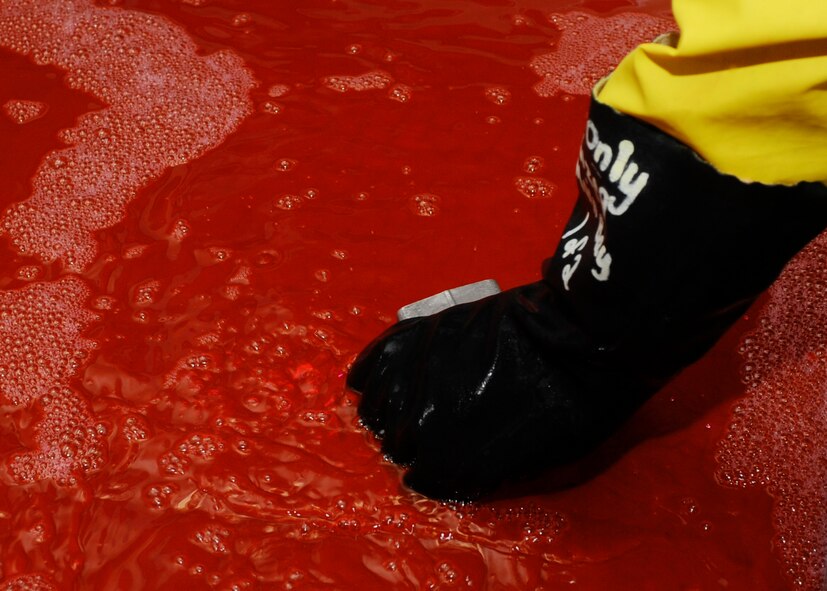 Airman 1st Class Charles Mills, 28th Maintenance Squadron nondestructive inspection technician, immerses a hydraulic accumulator into hydrophilic remover during an inspection at Ellsworth Air Force Base, S.D., Aug. 9, 2013. The hydrophilic remover fluid removes any excess penetrant from the surface of the part to prevent false indication readings, allowing for a proper inspection and examination. (U.S. Air Force photo by Airman 1st Class Anania Tekurio/Released) 