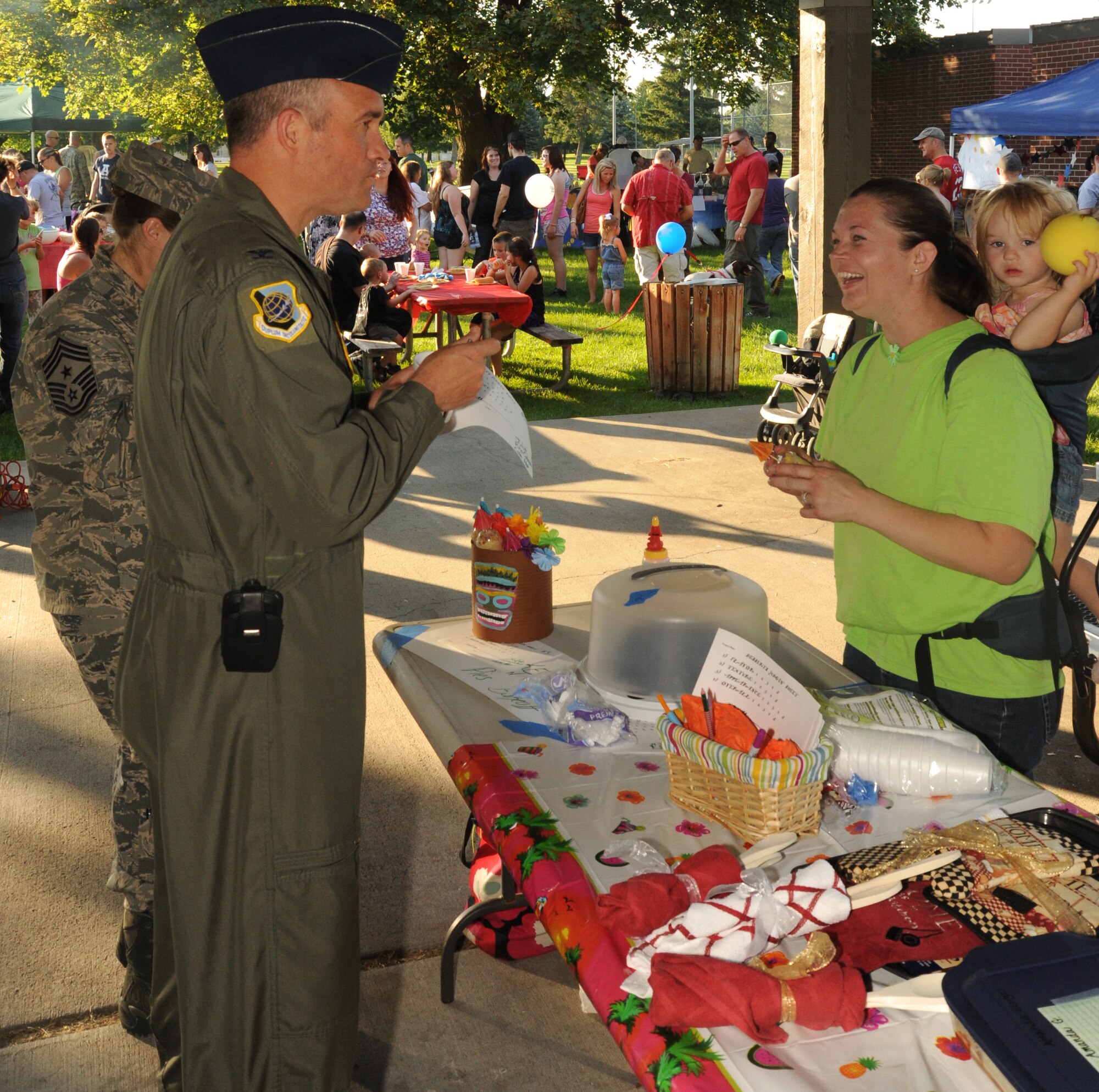 Col. Brian Newberry, 92nd Air Refueling Wing commander, samples selections from the baking competition as Tech. Sgt. Rebecca Miller, 92nd Maintenance Squadron Composite Tool Kit noncommissioned officer in charge, looks on at Fairchild Air Force Base, Wash., Aug. 6, 2013.  The baking competition was part of the National Night Out celebration at Miller Park.  (U.S. Air Force photo by Airman 1st Class Sam Fogleman/Released)
