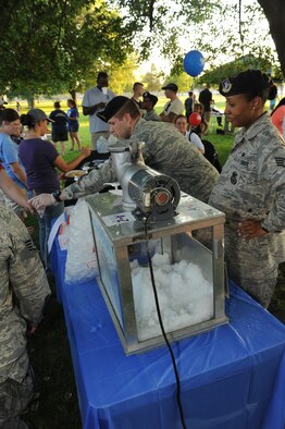 Senior Airman Michael Berg, 92nd Security Forces Squadron patrolman, and Staff Sgt. Denine Deal, 92nd Security Forces Squadron police services, work a snowcone station at Fairchild Air Force Base, Wash., Aug. 6, 2013.  The snowcone station was a part of the National Night Out celebration at Miller Park.  (U.S. Air Force photo by Airman 1st Class Sam Fogleman/Released)