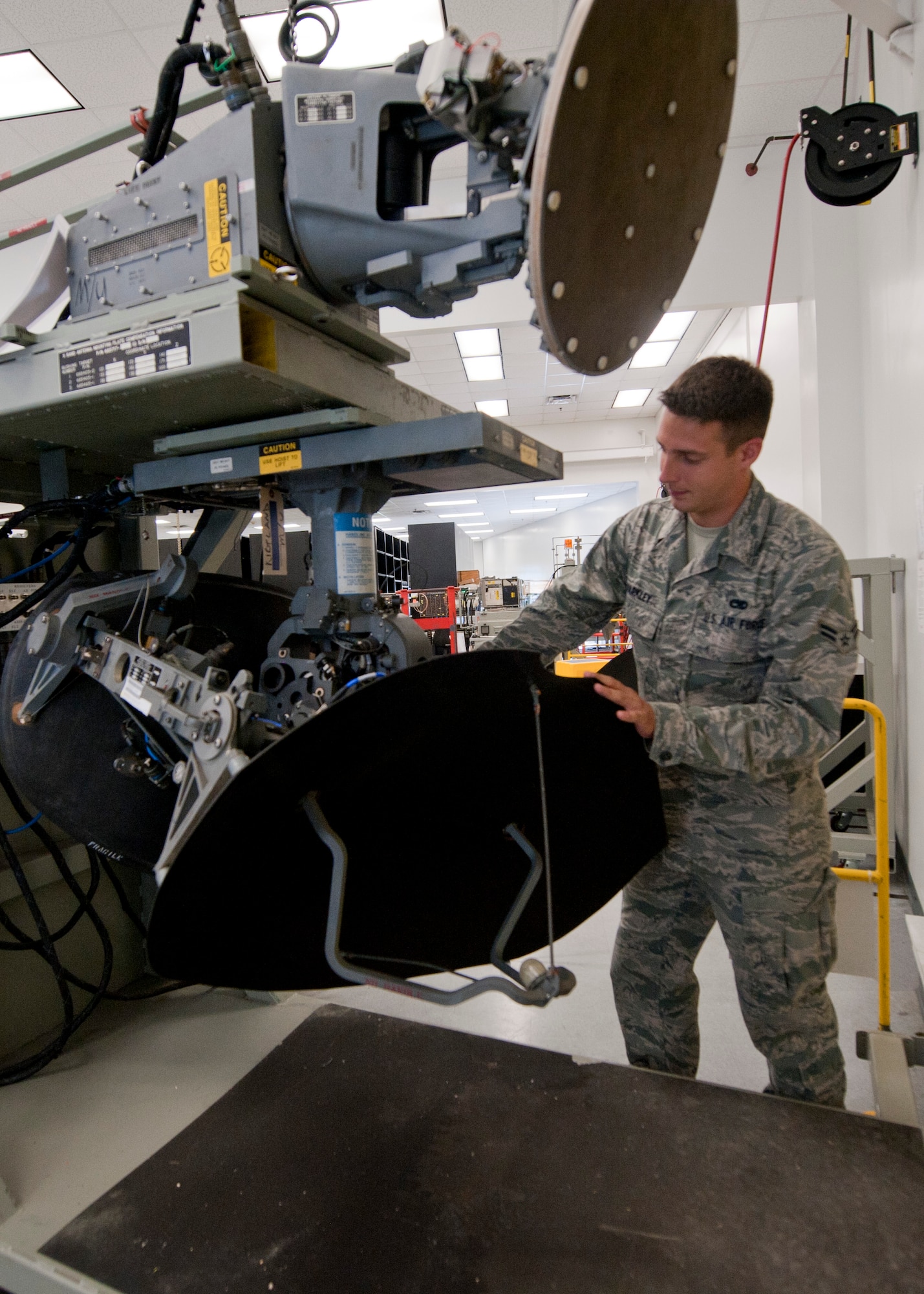 Airman 1st Class Zachary Barkley, 1st Special Operations Component Maintenance Squadron mission systems journeyman, makes adjustments to a bit oscillator on a KU band- antenna at the 1st SOCMS on Hurlburt Field, Fla., Aug. 7, 2013. The bit oscillator provides a three-dimensional image of precision ground-mapping and detects weather for the MC-130H Combat Talon II aircraft. (U.S. Air Force photo by Senior Airman Krystal M. Garrett) 