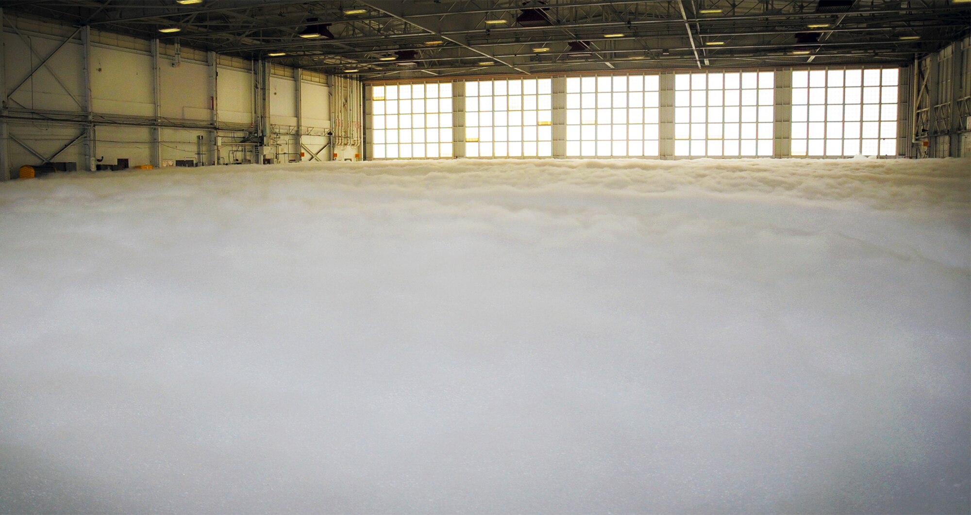 PATRICK AFB, Fla. -- The 920th Rescue Wing Maintenance Group tested one of its fire-suppression systems here today at 1 p.m. in Hangar 750. The system spews high-expansion foam from massive, fan-driven generators in the hangar ceiling. The foam is non-toxic and requires no clean up (it evaporates). According to Patrick AFB Assistant Fire Chief Dallas More, the system is capable of extinguising a fire in less than 30 seconds. Pictured above just after the test, the hangar floor covered in soft clouds of foam. (U.S. Air Force photo by Master Sgt. Paul Flipse)