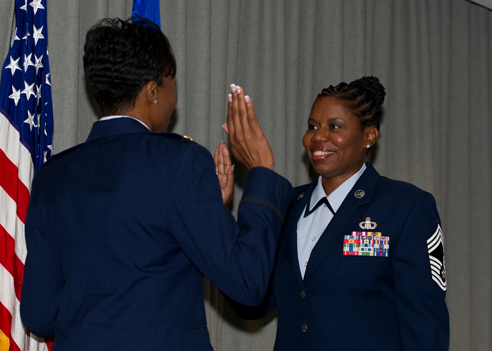 Chief Master Sgt. Jacinda Rivers, Air Force Special Operations Command command and control functional manager, right, raises her hand during her promotion ceremony to chief master sergeant during at ceremony at Hurlburt Field, Fla., July 27, 2012. The rank of chief master sergeant is limited by federal law to only one percent of the Air Force enlisted force. (U.S. Air Force photo / Airman 1st Class Christopher Callaway)