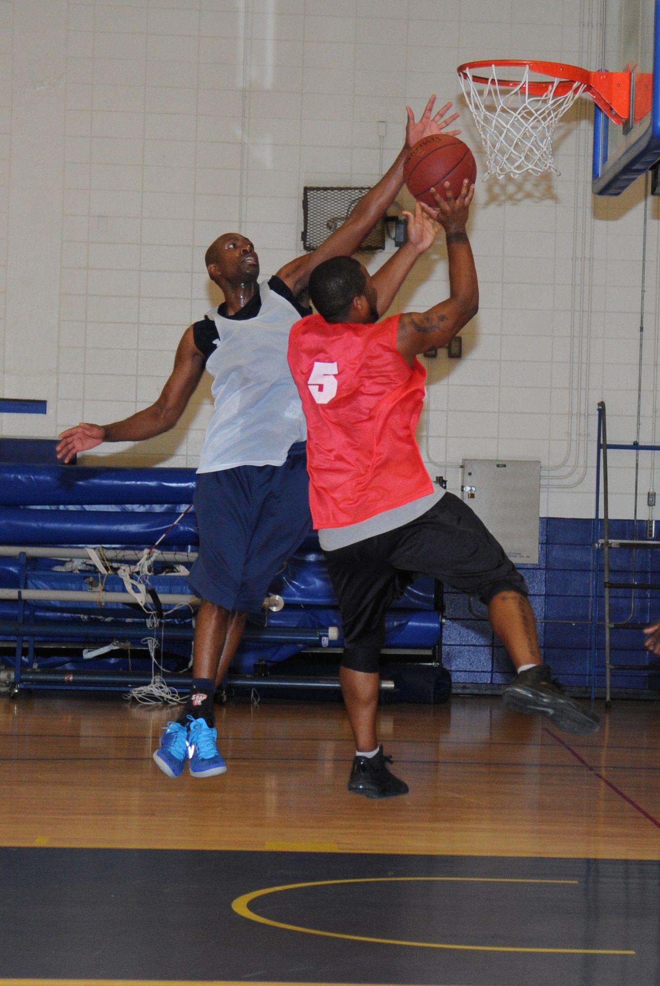 Alvin Holmes, 81st Medical Group, jumps to block Sam Dixon, 81st Communications Squadron, during an intramural basketball game Aug. 12, 2013, at the Blake Fitness Center, Keesler Air Force Base, Miss.  The 81st MDG defeated the 81st CS, 59-48.  (U.S. Air Force photo by Kemberly Groue)