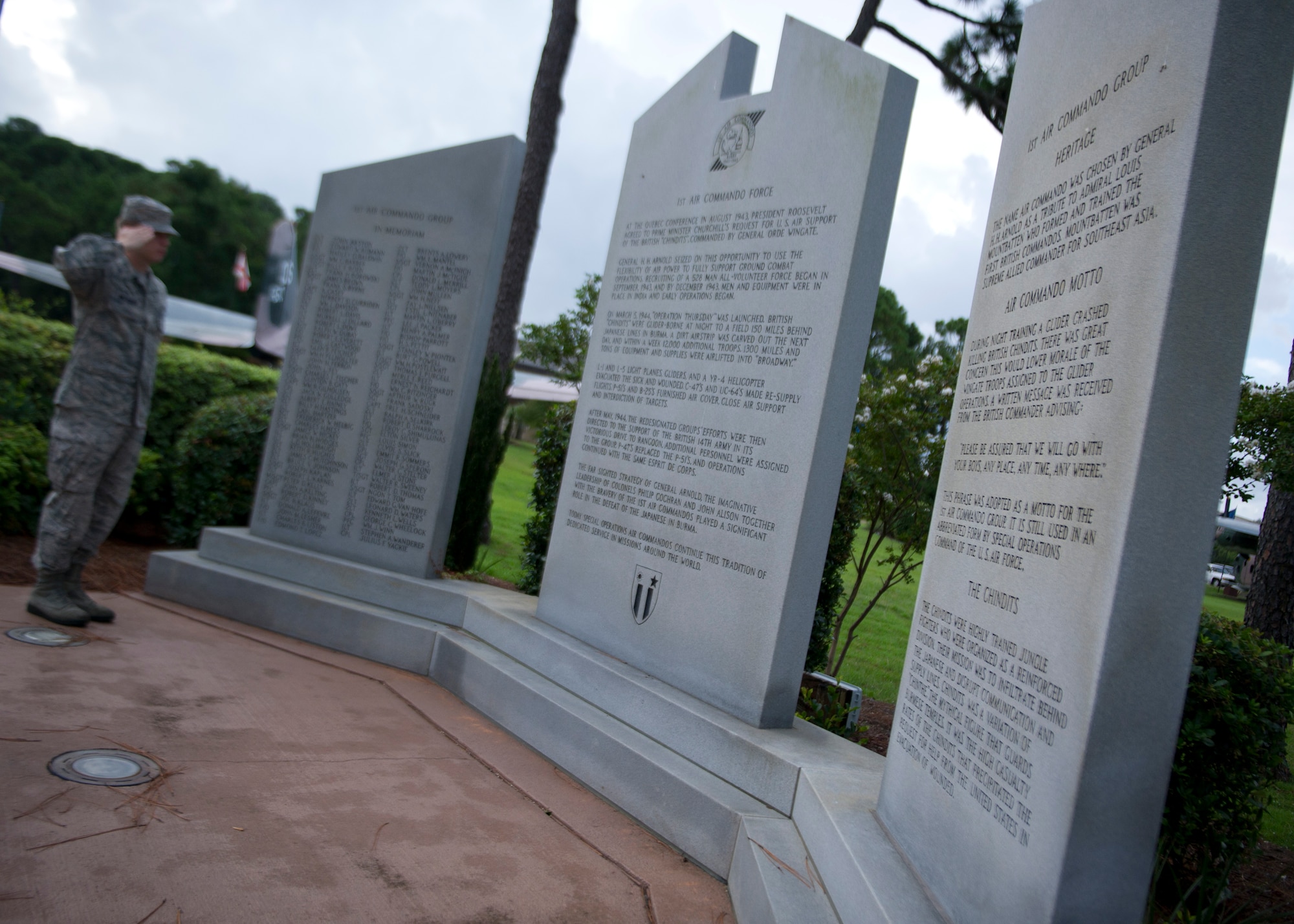 Senior Airman Joe W. McFadden, a photojournalist of 1st Special Operations Wing Public Affairs, salutes the Air Commando tablets at the Airpark at Hurlburt Field, Fla., Aug. 13, 2013. The stones bear the history of the 1st Air Commando Group dating back to the chindit flyers in Burma-Indo-China in 1943. (U.S. Air Force photo / Airman 1st Class Christopher Callaway)