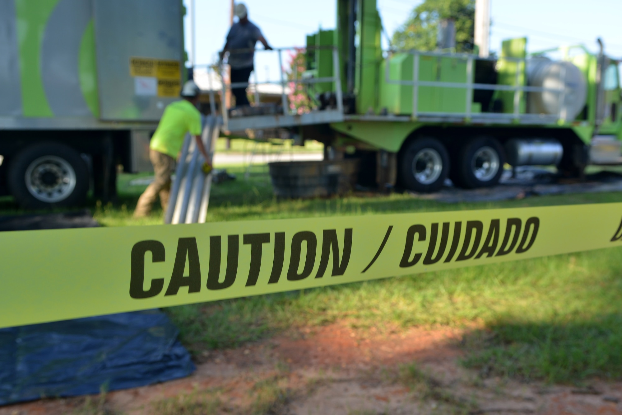 Caution tape surrounds an area that is about to be drilled for well cleaning as two URS Corporation drillers prepare for the job, Shaw Air Force Base, S.C., Aug. 12, 2013. Scheduled well maintenance will take place for the next two weeks.  (U.S. Air Force photo by Airman 1st Class Ashley L. Gardner/Released)