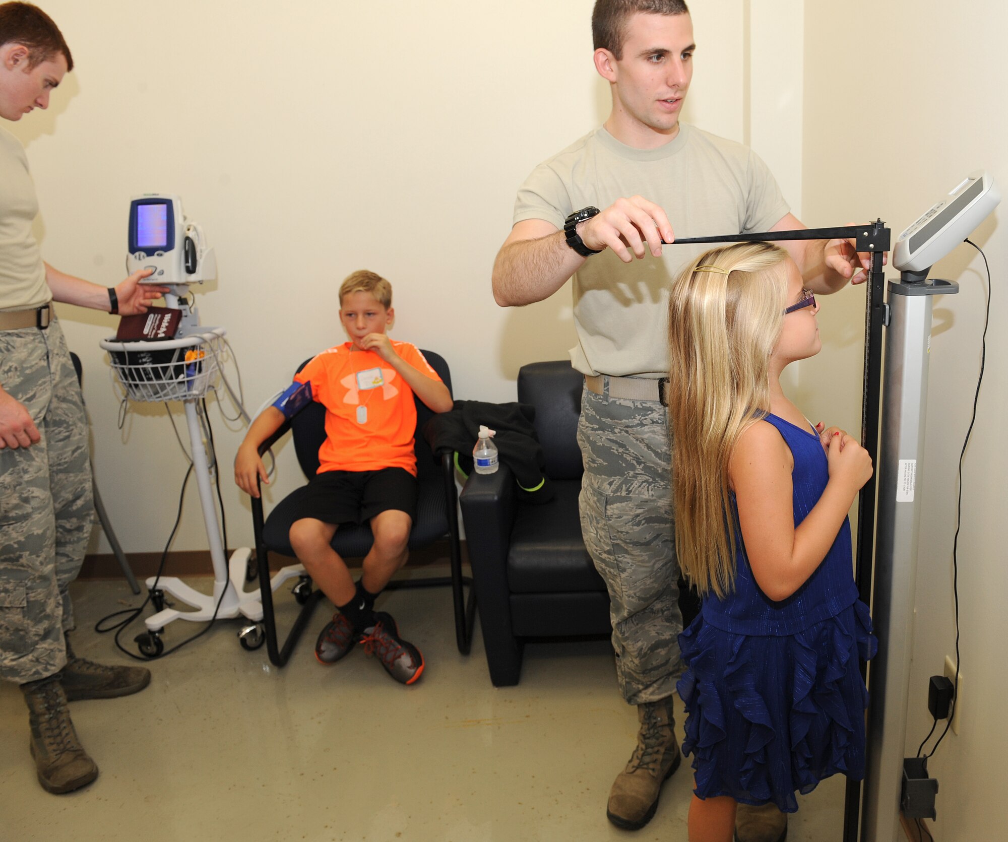 U.S. Air Force Airman 1st Class James Hennessey and Senior Airman David Stanley, 633rd Medical Operations Squadron cardio-pulmonary technicians, perform different madatory medical processes for deployment on Derek and Anne Percivalle during the annual Operation Hero event at Langley Air Force Base, Va., Aug. 7, 2013.  Operation Hero allowed children participate in a mock-deployment line, which included simulated immunizations and medication, as well as blood pressure tests and height and weight measurements. (U.S. Air Force photo by Senior Airman Brittany Paerschke-O’Brien/Released)
